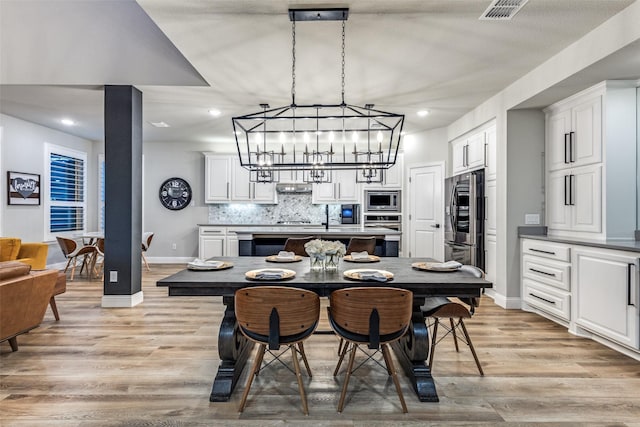 dining area featuring recessed lighting, visible vents, light wood-style flooring, and baseboards