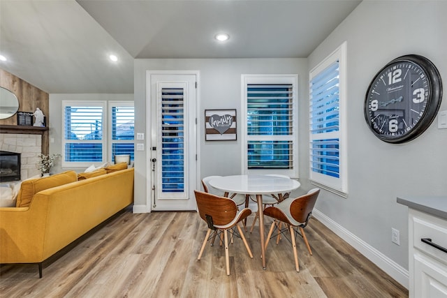 dining area with light wood-style floors, a fireplace, baseboards, and recessed lighting