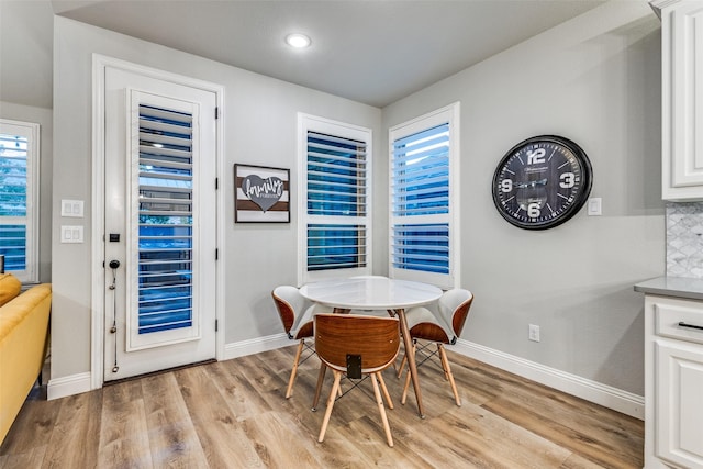 dining area with light wood-style floors and baseboards