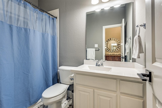 bathroom with a shower with shower curtain, a textured wall, vanity, and toilet