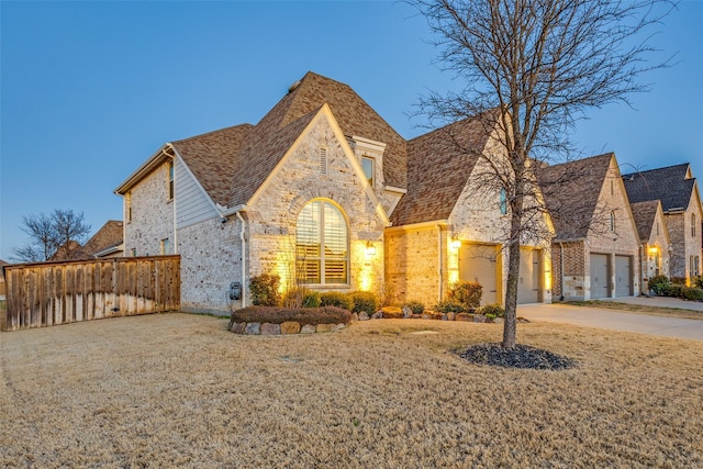 view of front of property featuring a garage, concrete driveway, and brick siding