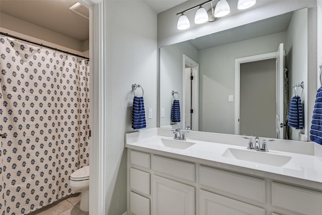 bathroom with tile patterned flooring, a sink, toilet, and double vanity