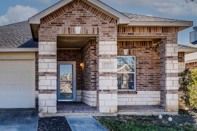 view of exterior entry with stone siding, brick siding, and a shingled roof