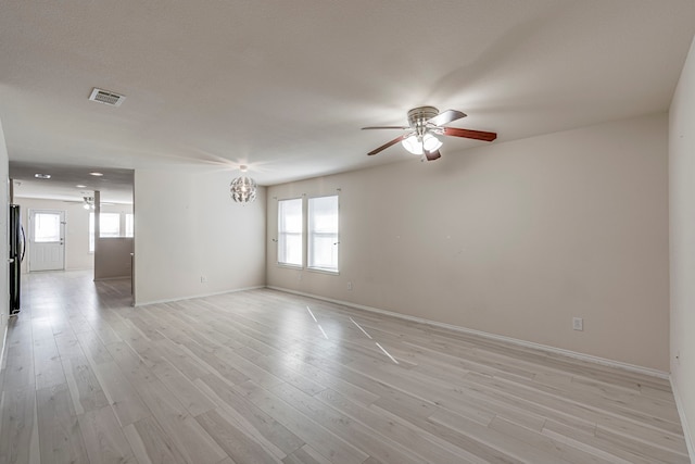 spare room with a wealth of natural light, light wood finished floors, and a ceiling fan