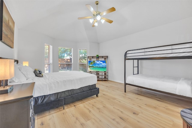 bedroom with ceiling fan, vaulted ceiling, and wood finished floors