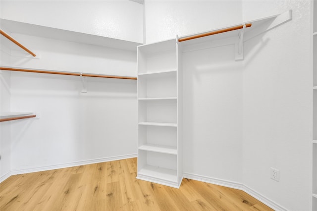 walk in closet with wood finished floors