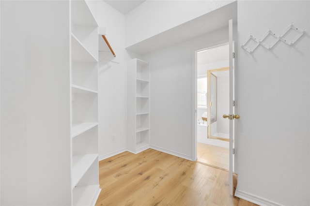 walk in closet with wood finished floors