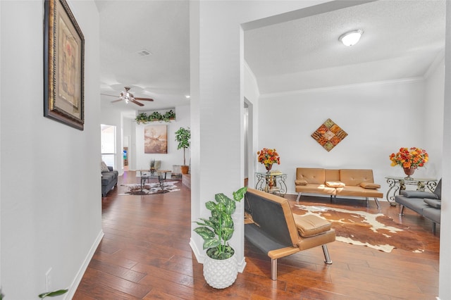 interior space with baseboards, crown molding, a textured ceiling, and hardwood / wood-style floors