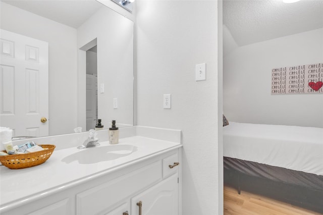 bathroom with vanity, a textured ceiling, and wood finished floors