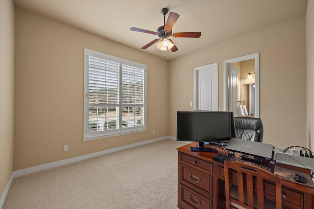 office area with a ceiling fan, light colored carpet, and baseboards