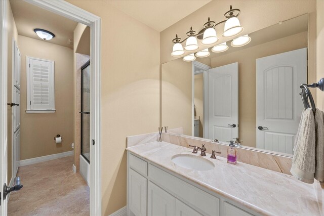 bathroom with an enclosed shower, vanity, and baseboards