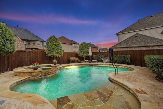 view of swimming pool with a fenced backyard, a pool with connected hot tub, and a patio area