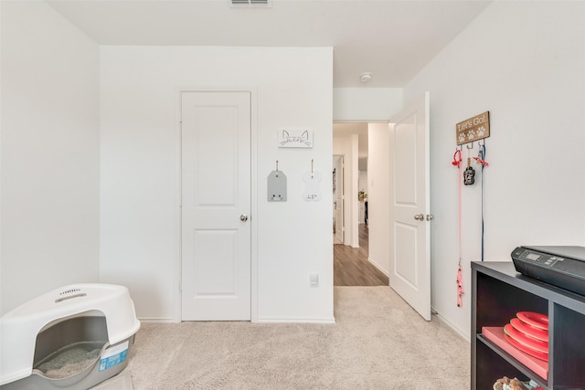 interior space with light colored carpet, visible vents, and baseboards