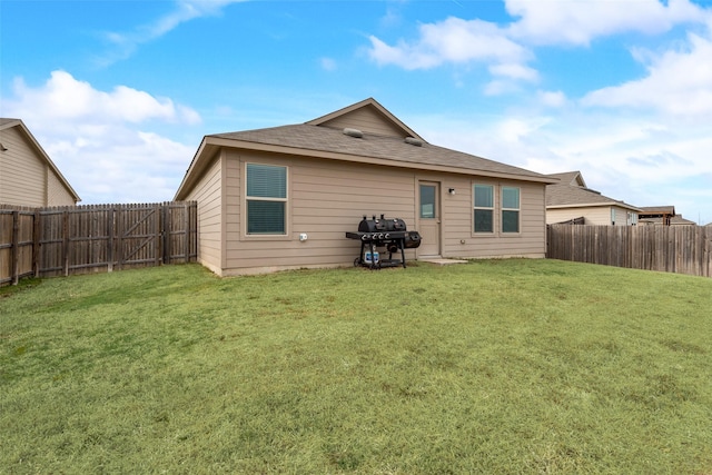 back of house featuring a fenced backyard and a lawn