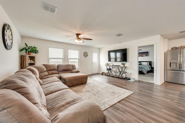 living area featuring visible vents, ceiling fan, and wood finished floors