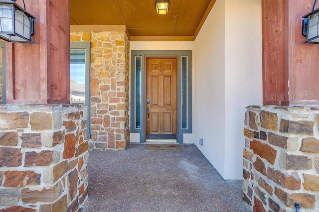 entrance to property with stone siding and stucco siding