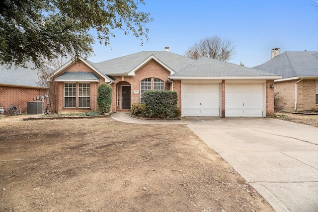 single story home featuring driveway, a shingled roof, an attached garage, central air condition unit, and brick siding