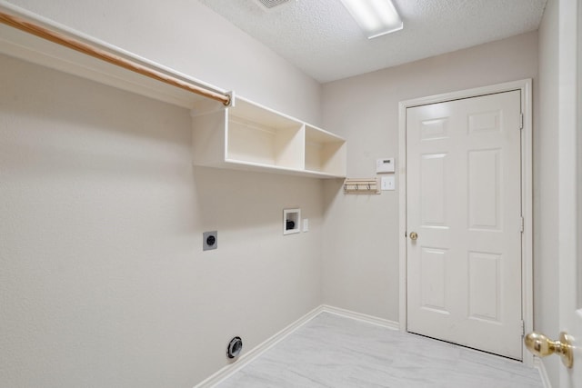 laundry area featuring a textured ceiling, hookup for an electric dryer, laundry area, washer hookup, and baseboards