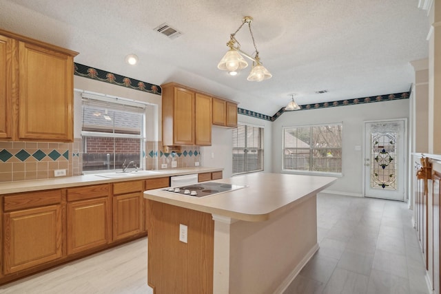 kitchen with electric stovetop, tasteful backsplash, a wealth of natural light, and a sink