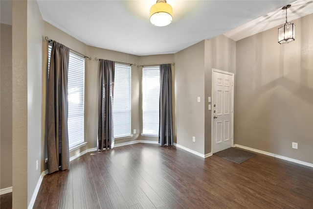 foyer featuring dark wood-type flooring and baseboards