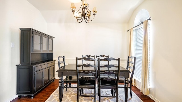 dining space with dark wood-style floors, baseboards, and an inviting chandelier