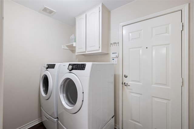 washroom featuring washer and dryer, cabinet space, visible vents, and baseboards