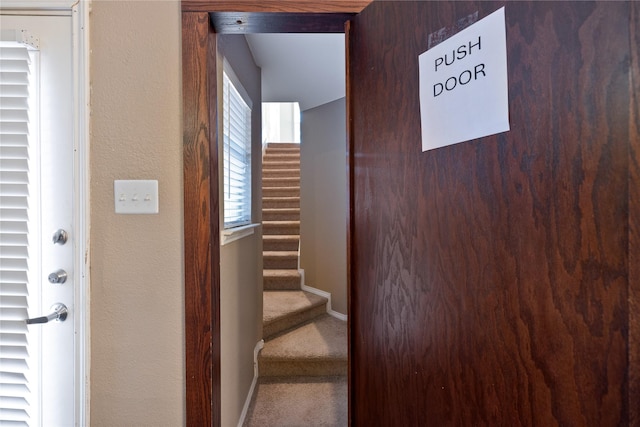 stairway featuring carpet and baseboards