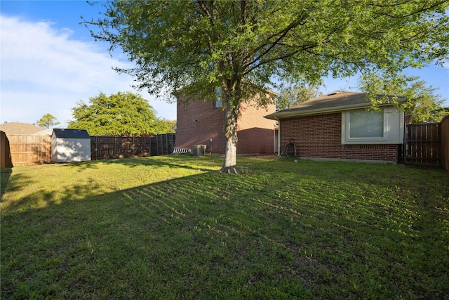 view of yard featuring a storage shed, an outdoor structure, and a fenced backyard