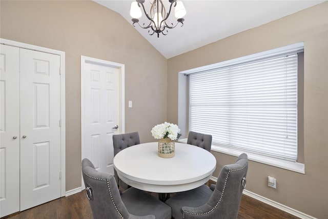 dining space featuring baseboards, a chandelier, vaulted ceiling, and dark wood finished floors