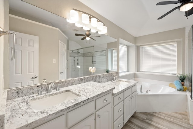 full bathroom featuring lofted ceiling, a garden tub, a sink, a shower stall, and double vanity