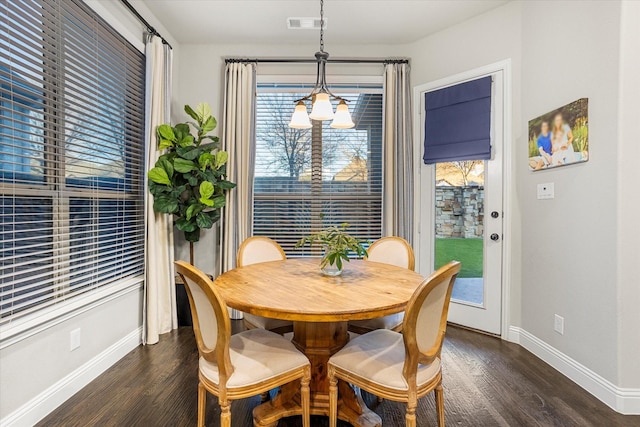 dining area with dark wood-style flooring, visible vents, and baseboards