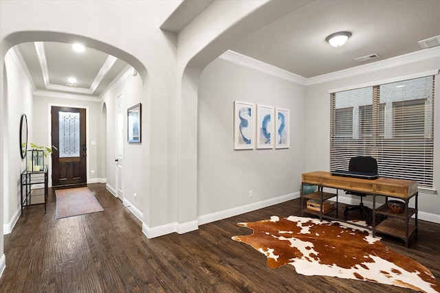 entryway with visible vents, arched walkways, dark wood finished floors, and ornamental molding