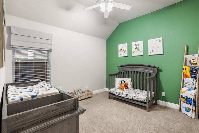 carpeted bedroom with a nursery area, lofted ceiling, a ceiling fan, and baseboards