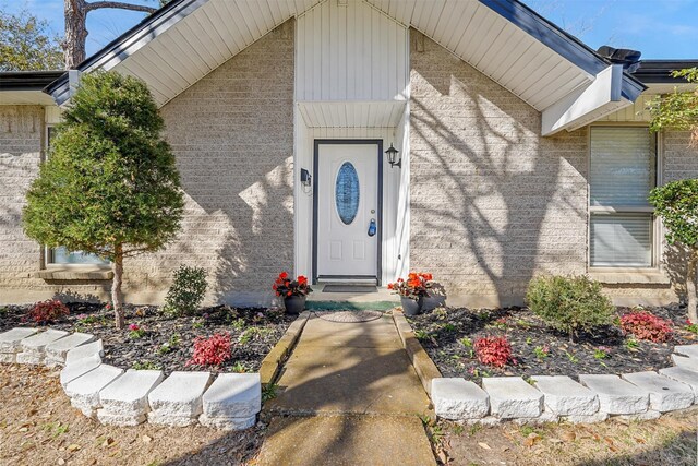 mid-century modern home featuring an attached garage, brick siding, driveway, and a front yard