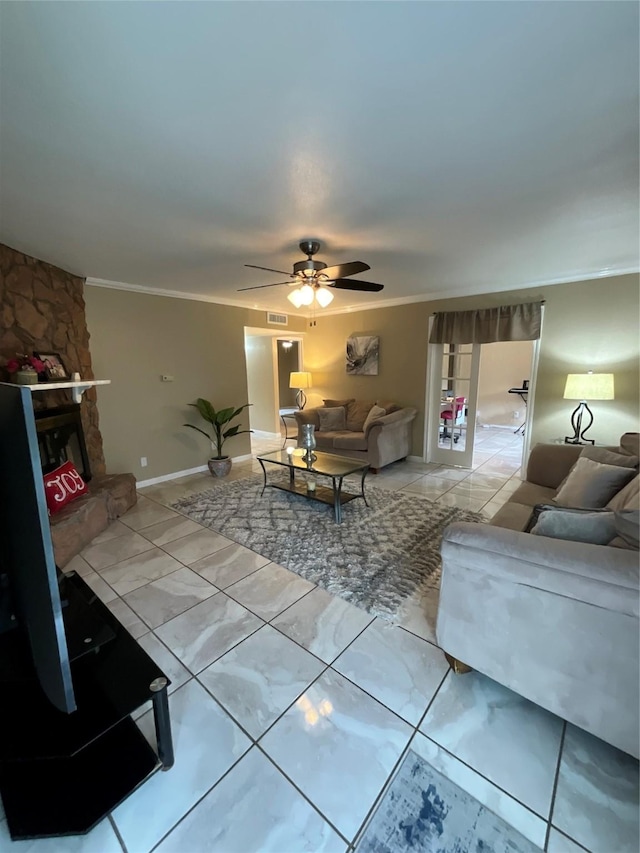 living area with a fireplace, a ceiling fan, and crown molding