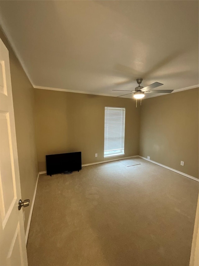 unfurnished room with a ceiling fan, light carpet, and baseboards