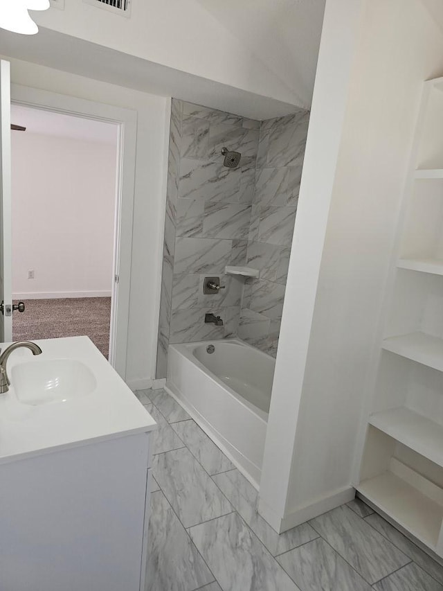 full bathroom featuring marble finish floor, baseboards, shower / washtub combination, and a sink