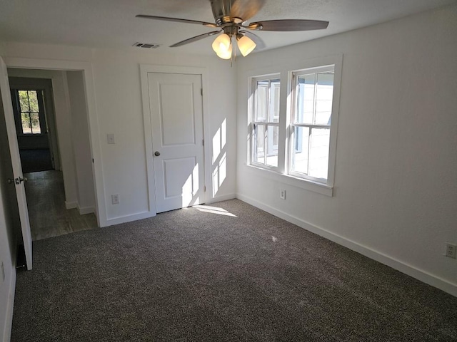 unfurnished bedroom featuring carpet floors, visible vents, ceiling fan, and baseboards