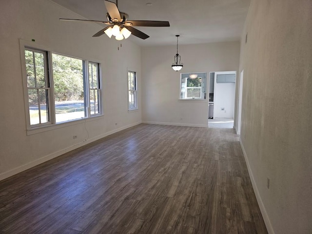 spare room featuring ceiling fan, baseboards, and dark wood finished floors