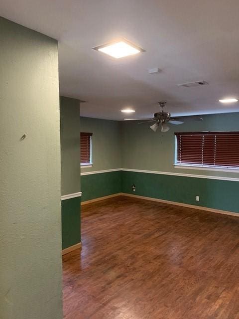 empty room with ceiling fan, baseboards, and wood finished floors