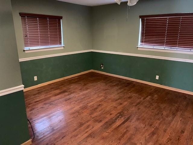 empty room featuring baseboards and wood finished floors