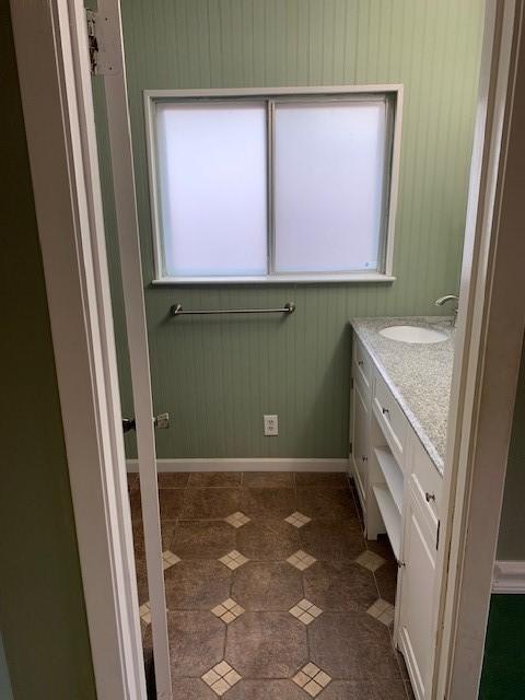 bathroom featuring tile patterned flooring, baseboards, and vanity