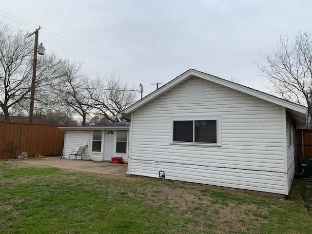 rear view of property featuring fence, a lawn, and a patio