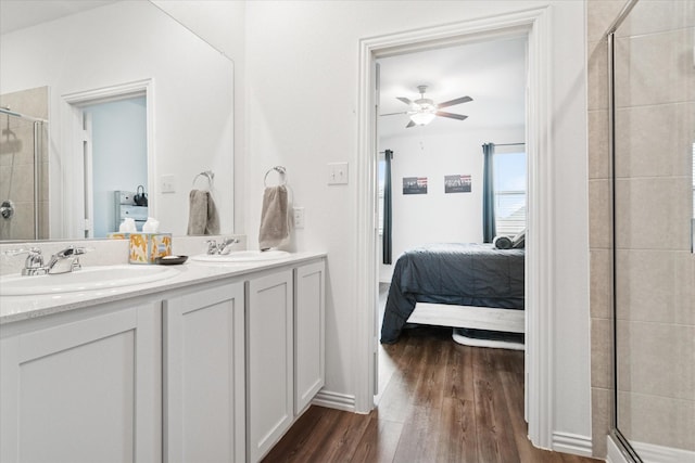 bathroom featuring a sink, a stall shower, connected bathroom, and wood finished floors