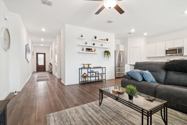 living area with dark wood-style floors, baseboards, visible vents, and recessed lighting