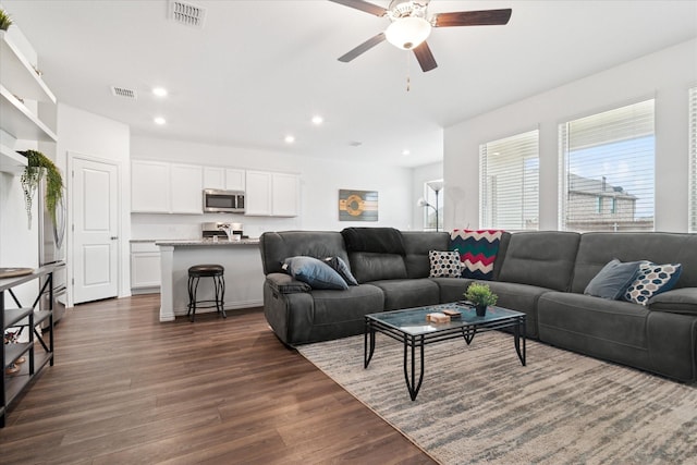 living room featuring dark wood-style floors, recessed lighting, and visible vents