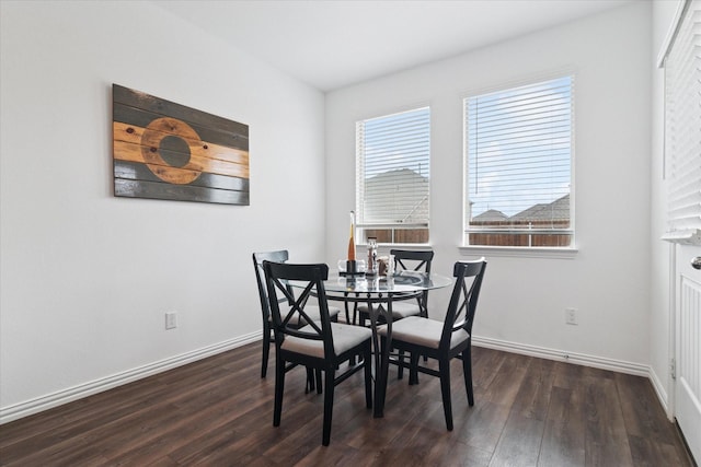 dining space featuring dark wood finished floors and baseboards