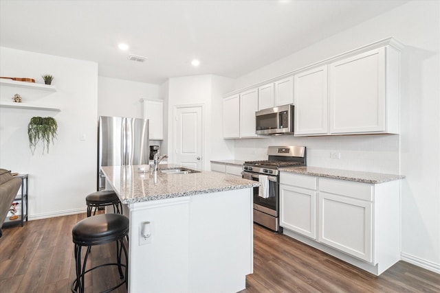 kitchen with visible vents, white cabinets, appliances with stainless steel finishes, dark wood-style flooring, and a sink