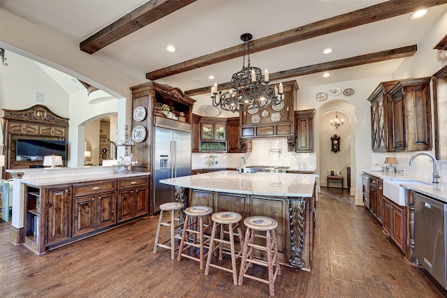 140 Manor Dr, Heath, TX 75032 - kitchen with stainless steel appliances, arched walkways, a sink, open shelves, and a chandelier