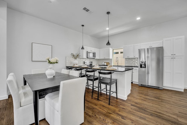 dining space featuring dark wood-style flooring, visible vents, and recessed lighting